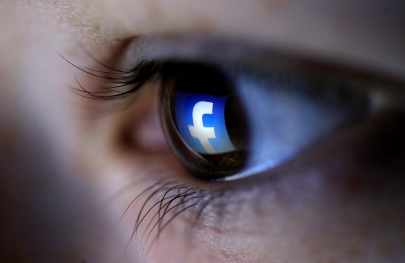 A picture illustration shows a Facebook logo reflected in a person's eye, in Zenica